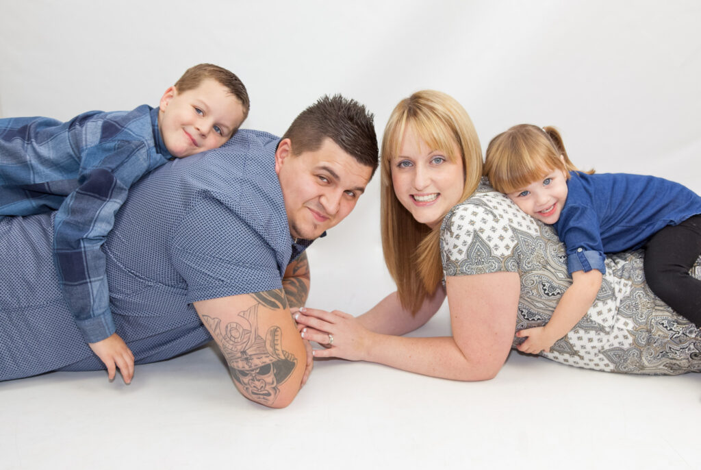 Family laying down - kids on parents backs - family studio photography session - kind words - Jo Buckley Photography